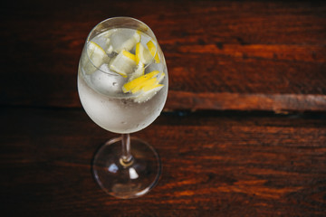 A glass of white wine on a rustic wooden red background. rest, holiday, party. crystal glass closeup. copy space. top view