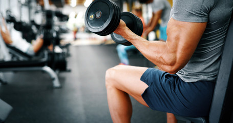 Fototapeta na wymiar Strong ripped man training in gym to reach goals