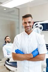 Handsome happy young man doctor in medical dentist center
