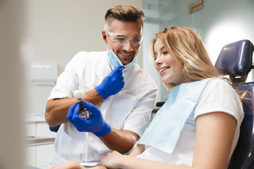 Happy young woman sitting in medical dentist center.