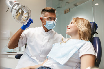 Happy young woman sitting in medical dentist center.