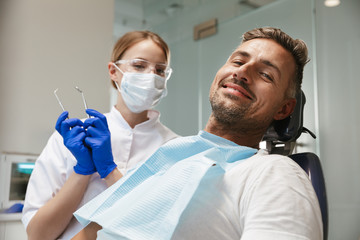 Happy young man sitting in medical dentist center.