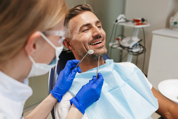 Happy young man sitting in medical dentist center.