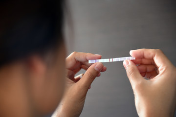 Woman holding positive pregnancy test.