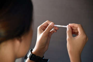 Obraz premium Woman holding positive pregnancy test.