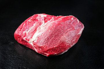 Raw dry aged wagyu silverside with eye of round piece as closeup on black background with copy space