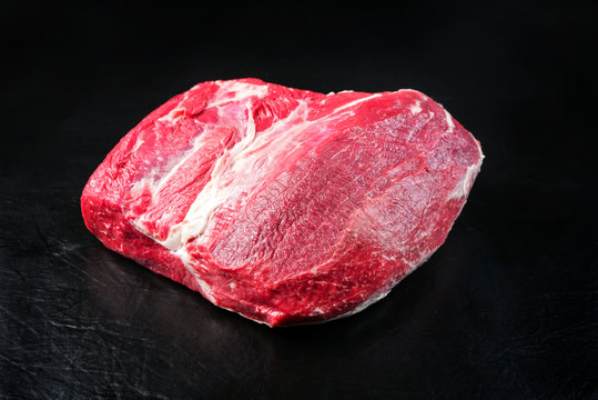 Raw dry aged wagyu silverside with eye of round piece as closeup on black background with copy space
