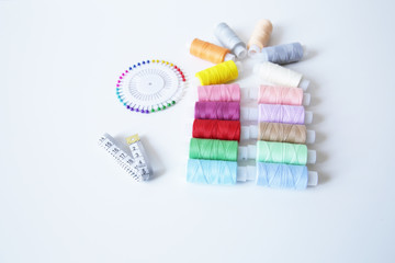 spools of thread, needles and meter on white background. With copy space for text.