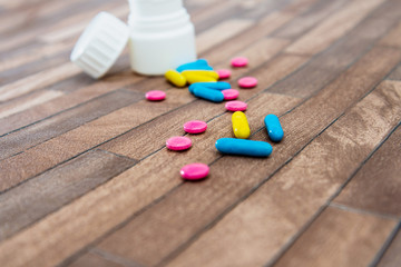 Health concept colorful medication and pills spilling out of a toppled bottle