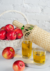 Apple juice in two glasses and apples.