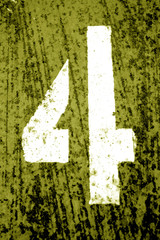 Number 4 in stencil on grungy metal wall in yellow tone.