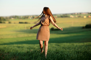 Happy girl running in the summer field