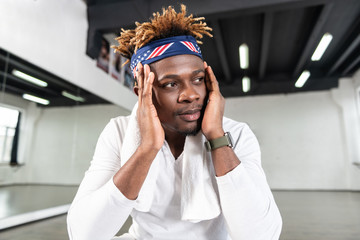 Serious good-looking dark-skinned man resting on floor