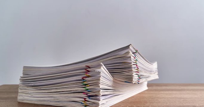 Pile overload paperwork of report on wood table time lapse