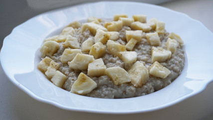 OATED POTENTA IN A PLATE WITH APPLES SALES AND A BANANA WHITE BACKGROUND