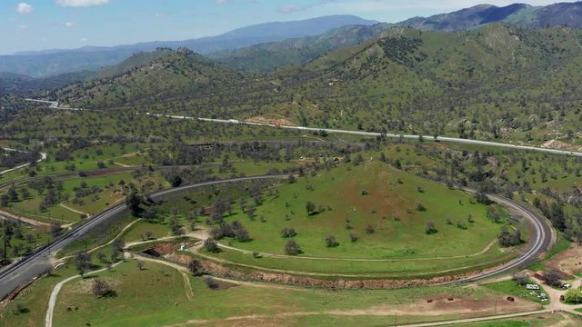 Tehachapi Loop railway in green spring mountains, Aerial Birds Eye View