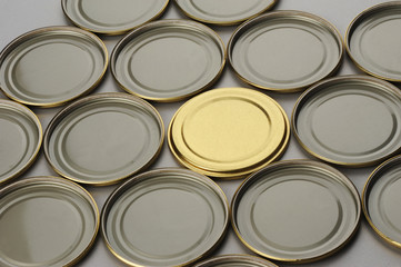 Screw cap for glass jars. For canning, canned food. One golden cap on gray background and flip covers