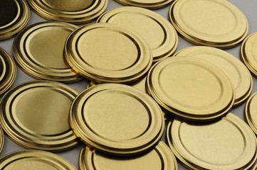 Screw caps for glass jars. For canning, canned food. Golden caps on gray background