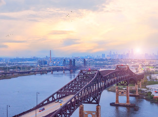 The view from the heights of the evening city of New York. View of the bridges and suburbs of New York at sunset.