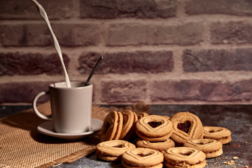 delicious bunch of sweet cookies next to a rich cup of hot milk