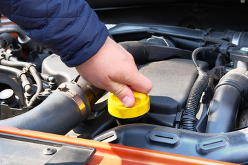 Car maintenance concept. Driver checking oil level in car engine. Cars and transportation, hand close up.