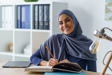 Smiling Arabian woman sitting