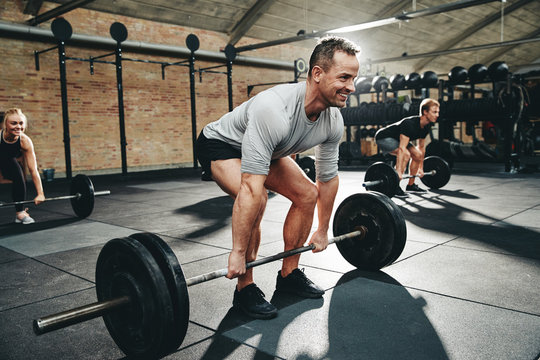 Fit man smiling during a gym weightlifting class