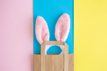 Top view of bunny ears in shopping bag on multicolored background abstract.