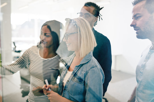 Smiling colleagues using sticky notes to brainstorm during a mee