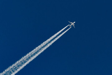 Airplanes leaving contrail trace on a clear blue sky.