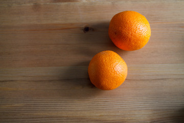 two oranges on a wooden background