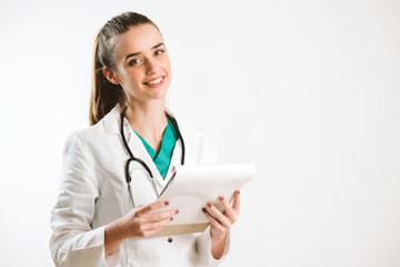 Young nurse with stethoscope and papers in her scrub uniform.