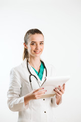 Young nurse with stethoscope and papers in her scrub uniform.