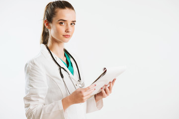 Young nurse with stethoscope and papers in her scrub uniform.