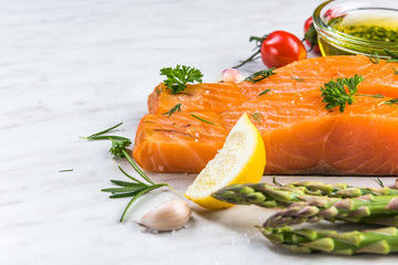 Fresh salmon fillets on white marble table