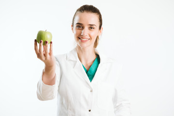 Young nurse holding an apple, a healthy snack. 