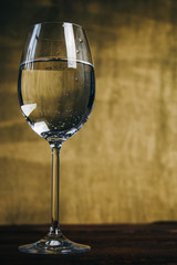 cropped glass of white wine on a rustic wooden brown background. rest, holiday, party. alcoholic drink closeup. copy space