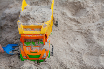  Bright toy transport truck on the sand. Free space.