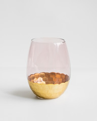 New pink glass with gold bottom on isolated background.