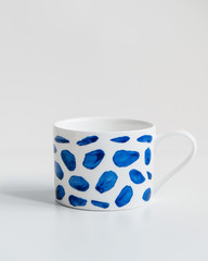 New white mug with blue dots on isolated background.