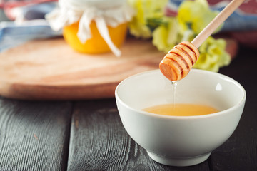 Honey background. Sweet honey in glass jar on wooden background.