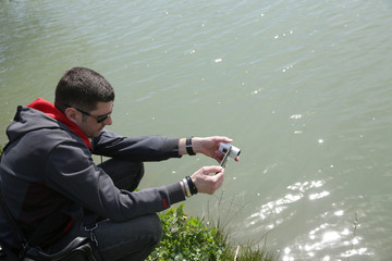  4K digital camera in the hands of a young man shooting on the river
