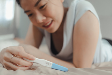 Young asian woman looking at pregnance test in happiness.Pregnancy family concept