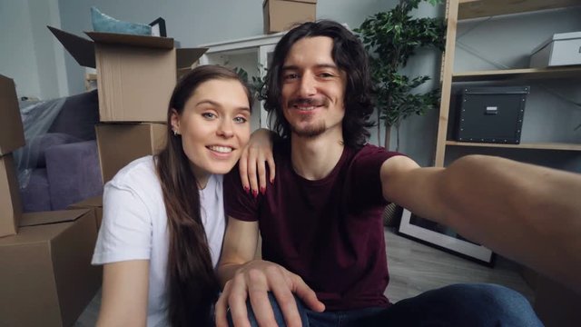POV shot of happy people making online video call at home holding house keys talking smiling kissing and looking at camera. Communication and relocation concept.