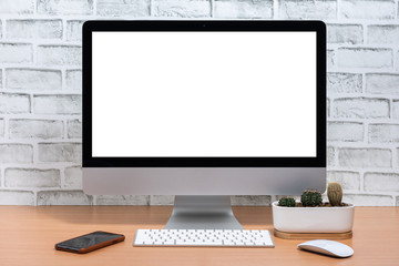 Blank screen of All in one Computer with smart phone and cactus pot on wooden table, White brick wall background
