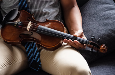 The wooden violin was holding by human hand,blurry light around