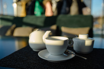 white cup with kettle on cafe table