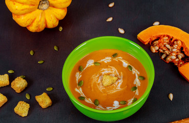 Homemade pumpkin cream soup on wooden background