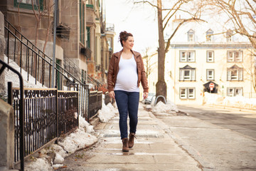 Pregnant girl outside on a city background