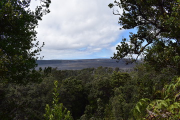 Kilauea Volcano Crater in Hawaii viewed from a distance with smoke rising from the crater